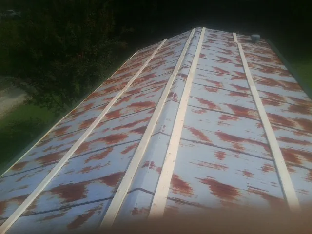 Rusted metal roof panels with new wood purlins before replacement — Storm Damage Roof Repair in Sun City West by Roofing Brothers
